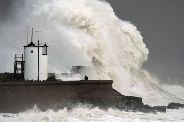 Waves crash over the sea wall at Porthcawl in Wales
