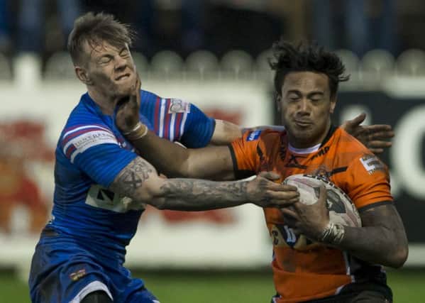 Wakefield's Tom Johnstone is fended off by Castleford's Denny Solomona. (Picture: Allan McKenzie)