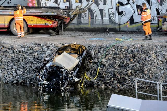 A badly damaged car is towed up from the canal under the E4 highway bridge in Sodertalje, Sweden, Saturday, Feb.13, 2016. Swedish police say five people have been killed when their car plunged more than 25 meters (82 feet) from a highway bridge into a canal in the capital of Stockholm. (Picture: Johan Nilsson/TT News Agency via AP)