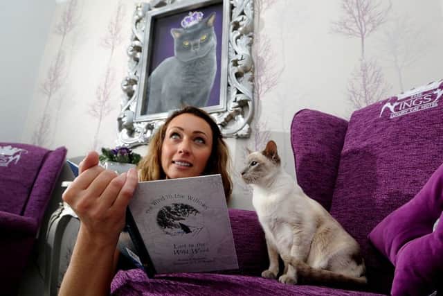 Luxury Cat Hotel owner Jo Ounsley showing a resident called Millie the menu.