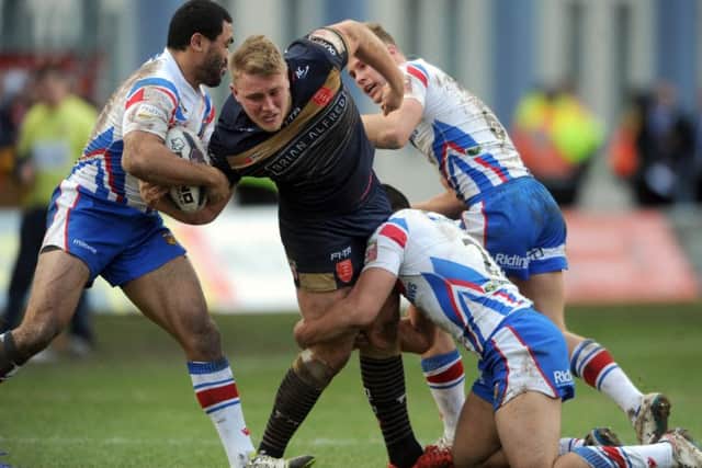 James Greenwood is forced to the ground by Wakefield's Bill Tupou, Michael Sio, and Jacob Miller.