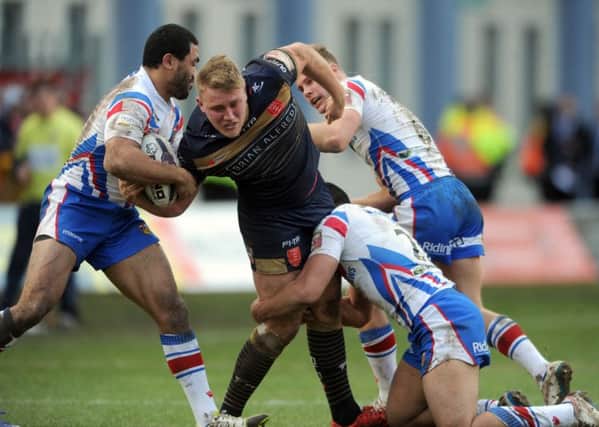 James Greenwood is forced to the ground by Wakefield's Bill Tupou, Michael Sio, and Jacob Miller.