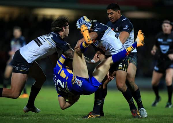 North Queensland Cowboys Ethan Lowe (left) and Johnathan Thurston tackle Leeds Rhinos Ash Handley.