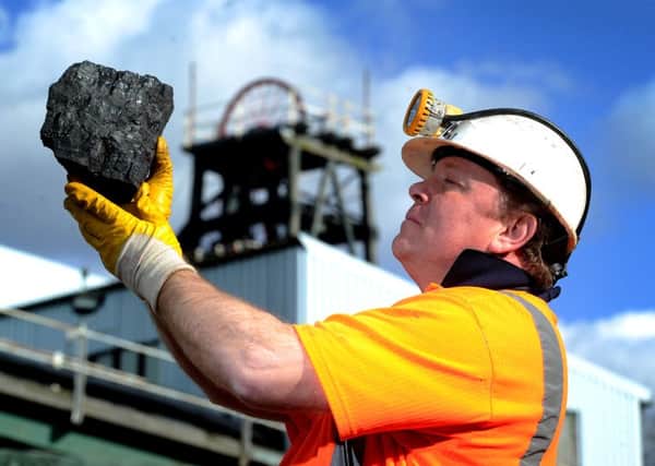 Former miner Ian Cunniff, who used to work at Kellingley Colliery for 11 years holds up one of the last pieces of coal to be brought to the surface.