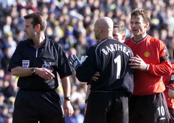 Manchester United goalkeeper Fabien Barthez is held back by Teddy Sherringham as he tries to confront referee Graham Barber after he committed a foul on Leeds United's Ian Harte.
