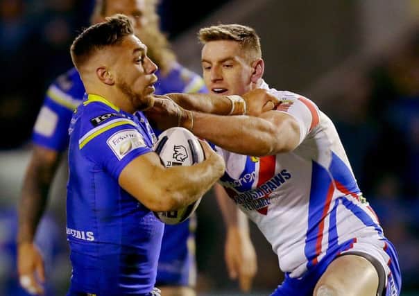 Warrington Wolves' Matty Russell (left) is tackled by Wakefield Trinity Wildcats' Jonny Molloy.