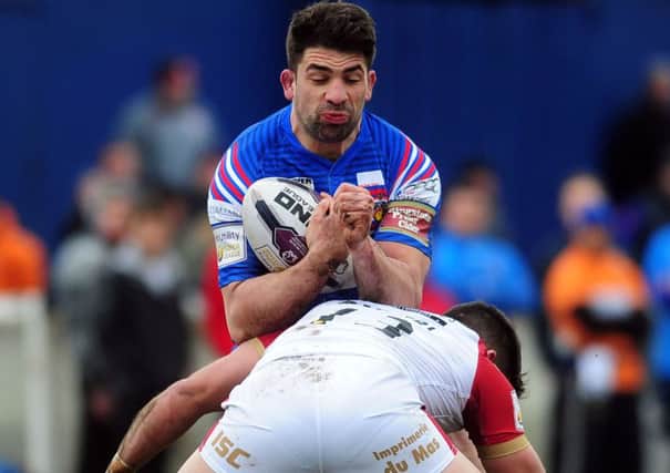 Late-game 
Wakefield try scorer's Mickael Simon is tackled by Catalan's Jason Baitieri. PIC: Jonathan Gawthorpe