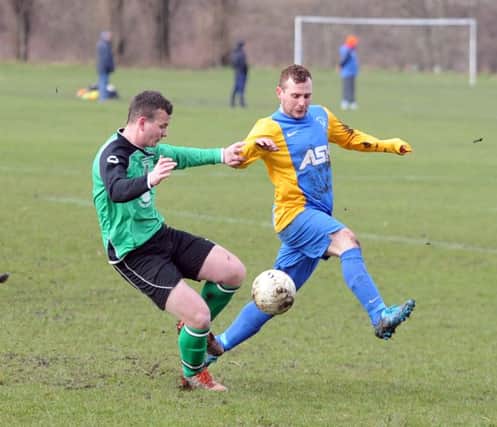Asa Audsley  of Chickenley and Kyle Douglas of Mirfield Town challenge for the ball