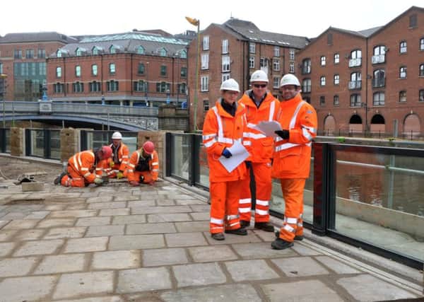 Environment Agency flood recovery team members by the new flood defences along the river in Dock Street. PIC: Tony Johnson