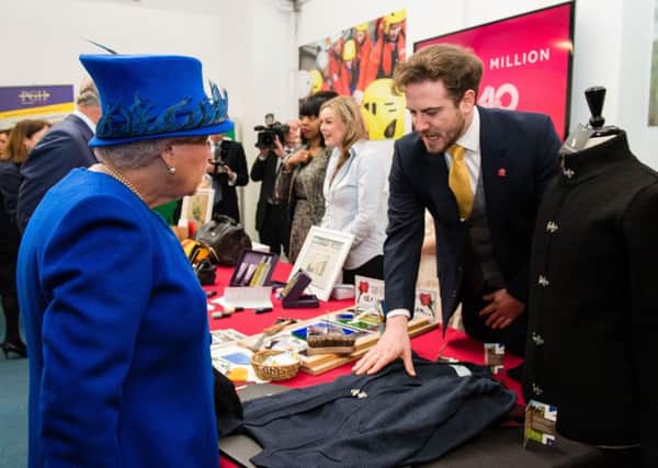 Ross William Barr-Hoyland shows off his knitwear collection to the Queen.