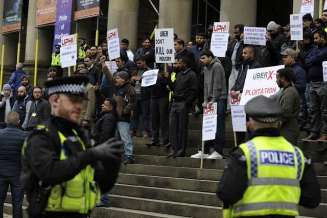 Taxi drivers protest at Leeds Town Hall to protest at minimum fare cuts of almost a fifth which are being imposed by Uber, the controversial app-based private hire operator.  18 March 2015.  Picture Bruce Rollinson
