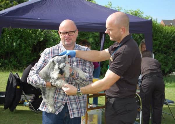 Dog warden Gavin Jarrett checks the microchip for Councillor Mark Dobson's dog, Velma