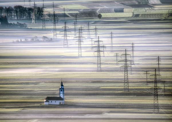 The winning photograph of the Church of St Ursula and power lines in Siroko Polje, Slovenia. PIC: Andrej Tarfila