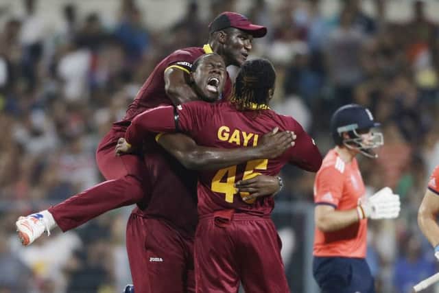 West Indies players Darren Sammy, Carlos Brathwaite and Chris Gayle celebrate the dismissal of England's Jos Buttler. Picture: AP/Saurabh Das.