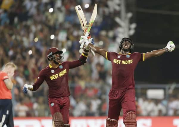West Indies' Carlos Brathwaite, right, celebrates with team-mate Marlon Samuels after they defeated in England at Eden Gardens . Picture: AP/Saurabh Das.