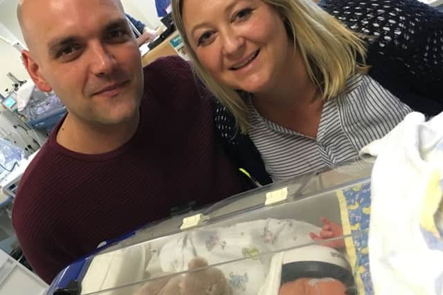 Baby Alistair James Beman with his parents Sally Senton and Nikki Beman.