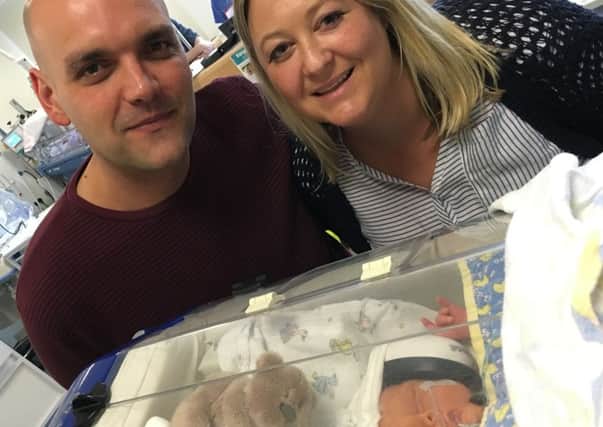 Baby Alistair James Beman with his parents Sally Senton and Nikki Beman.