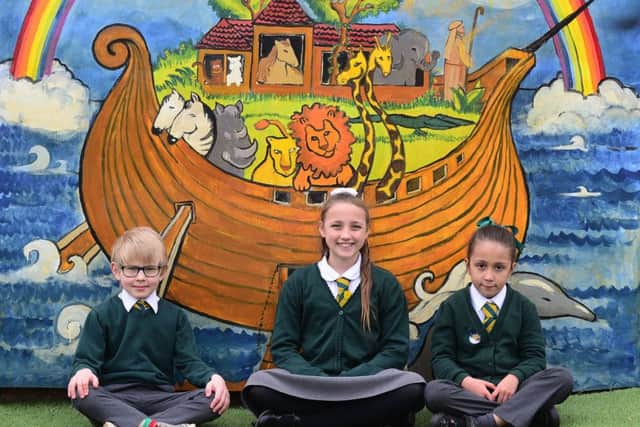Sebastian Griffiths, Isabella Bene-Hamill and Olivia Garcia-Torres in front of the mural in the newly refurbished playground at St Joseph's Catholic Primary School in Pudsey. PIC: Scott Merrylees