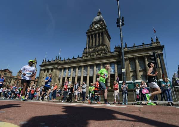The runners make their way past Leeds Town Hall  towards the finish of the race.