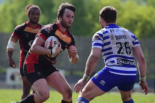 Dewsbury Rams' Scott Hale takes on Wigan's Greg Burke.
