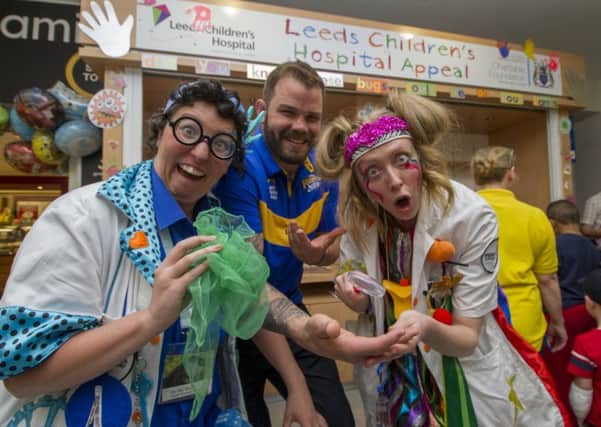 Rhinos star Adam Cuthbertson pictured with the Giggles Doctors, from the Theodora Children's Charity, at Leeds Children's Hospital. Picture by James Hardisty.