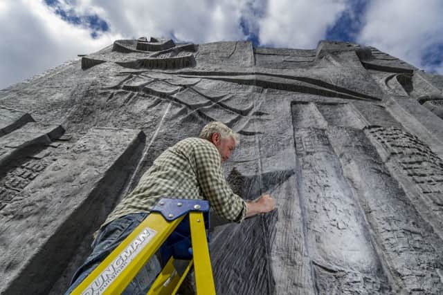 Matt Fairley, sculpture conservator and installer from Holmfirth, puts the finishing touches to the Untitled Bas-Relief, by Hubert Dalwood. Picture: James Hardisty.