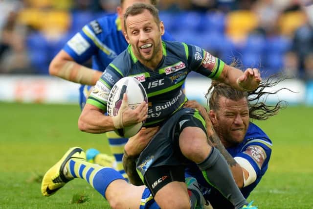 Rob Burrow's is hauled down by Warrington Wolves' Ashton Sims.  Picture: Bruce Rollinson.