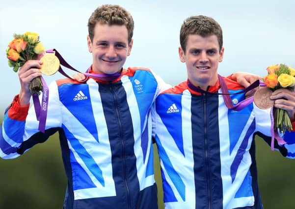 Great Britain's Alistair Brownlee celebrates with his gold medal and Jonathan Brownlee (right) after the Men's Triathlon on the eleventh day of the London 2012 Olympics.