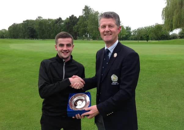 Tom Gray receives the Yorkshire Boys championship trophy from Yorkshire Union of Golf Clubs president Jonathan Plaxton.