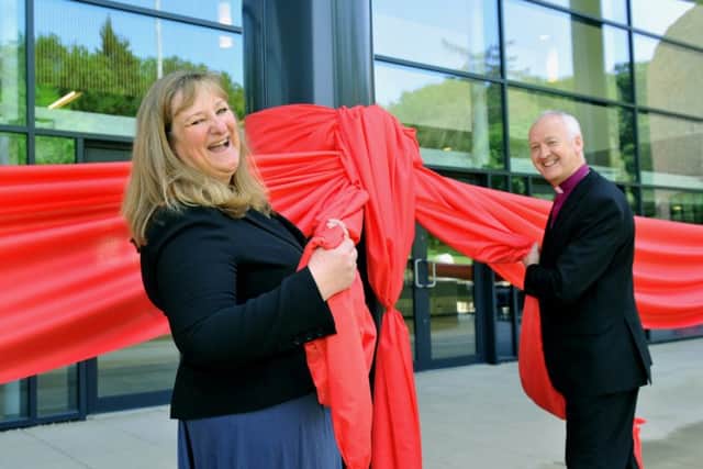 Heather Parry, deputy chief executive of the Yorkshire Agricultural Society, pulls a red ribbon with the Bishop of Leeds, Nick Baines, to officially open the new hall. (GL1010/36h)