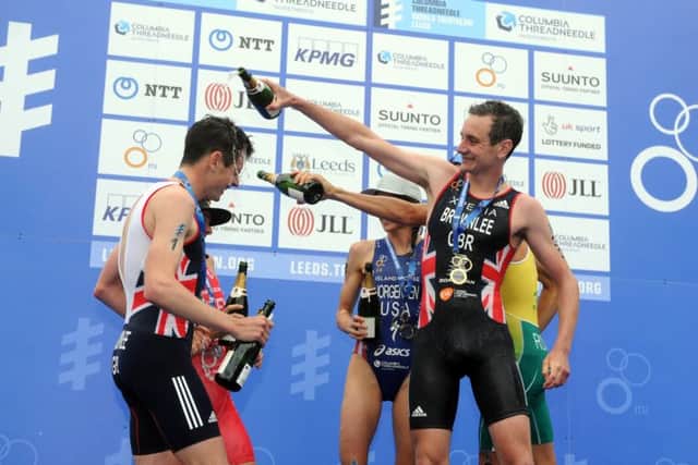 Alistair Brownlee celebrates his win of the 2016 ITU World Triathlon Leeds by soaking his brother Jonny in champagne on the podium in Millenium Square.  Picture Tony Johnson