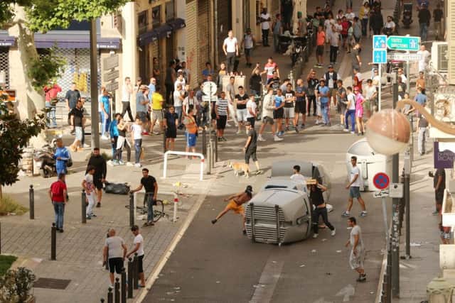 Football fans knock over bins and throw bottles ahead of the England's game against Russia in Marseille. Niall Carson/PA Wire