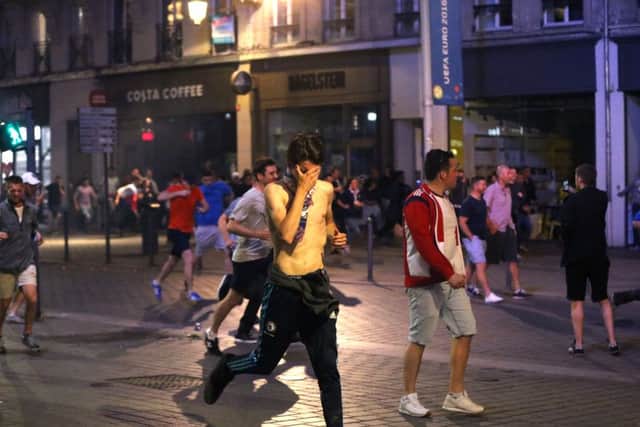 Football fans of differing nationalities and innocent bystanders try to escape tear gas fired by French police in Lille city centre, France, as fresh clashes have taken place between England fans and Russian hooligans at Euro 2016.  Picture: Niall Carson/PA Wire
