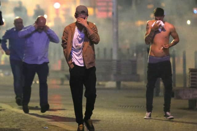 Football fans of differing nationalities and innocent bystanders try to escape tear gas fired by French police in Lille city centre, France, as fresh clashes have taken place between England fans and Russian hooligans at Euro 2016.