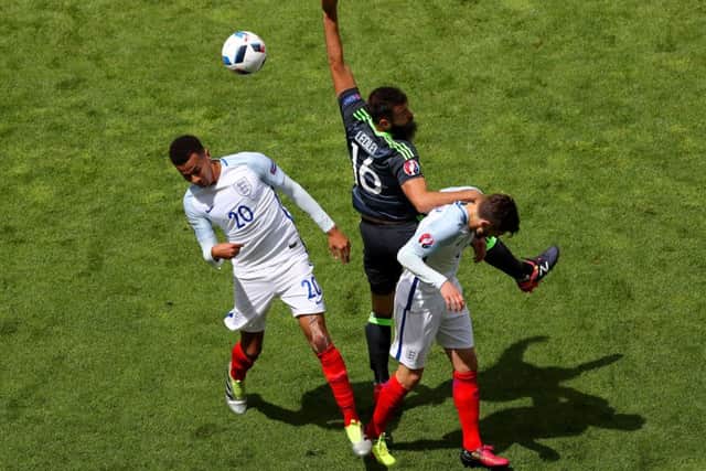Wales' Joe Ledley (centre) battles for the ball with England's Dele Alli (left) and Adam Lallana (right). Picture: Owen Humphreys/PA