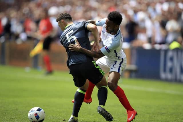 England's Raheem Sterling and Wales' James Chester during the Group B match at the Stade Felix Bollaert-Delelis. Picture: Mike Egerton/PA.