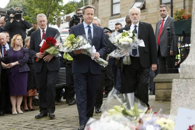 Shadow foreign secretary Hilary Benn, Prime Minister David Cameron and Labour Party leader Jeremy Corbyn lay flowers in Birstall. PIC: PA