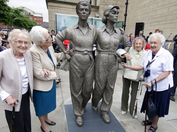 Women Of Steel survivors with their statue in Barker's Pool outside Sheffield City Hall
