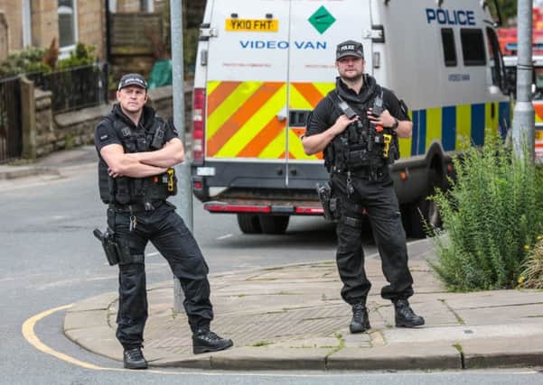 Armed police guard the scene in Birstall where local MP Jo Cox was shot and stabbed on Thursday.