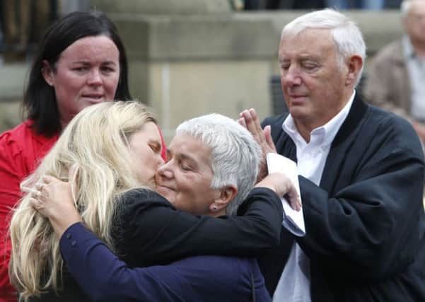 Jean Leadbeater, the mother of Labour MP Jo Cox, embraces her sister Kim Leadbeater while her father Gordon looks on, as they look at floral tributes left in Birstall.