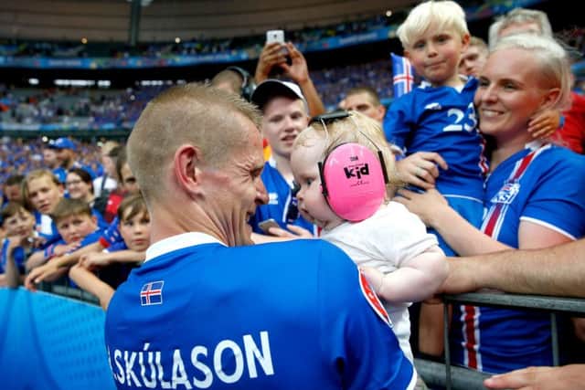 Iceland's Ari Freyr Skulason holds a baby from the crowd as he celebrates qualifying for the last 16 round after the Euro 2016, Group F match at the Stade de France, Paris. (Picture: Owen Humphreys/PA Wire).