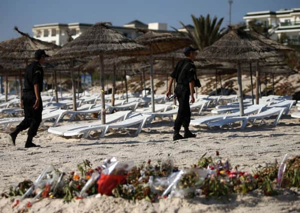 Police officers patrolling the beach after the attack in Tunisia. Credit: Steve Parsons/PA Wire