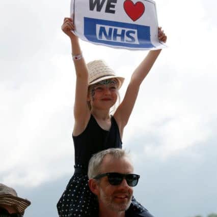 A young girl holds a We heart NHS sign in the crowds during the The Lewisham and Greenwich NHS Choir performance. Picture: Yui Mok/PA Wire
