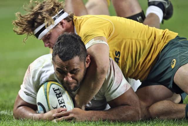 England's Billy Vunipola scores a try as he is tackled by Australia's Michael Hooper.