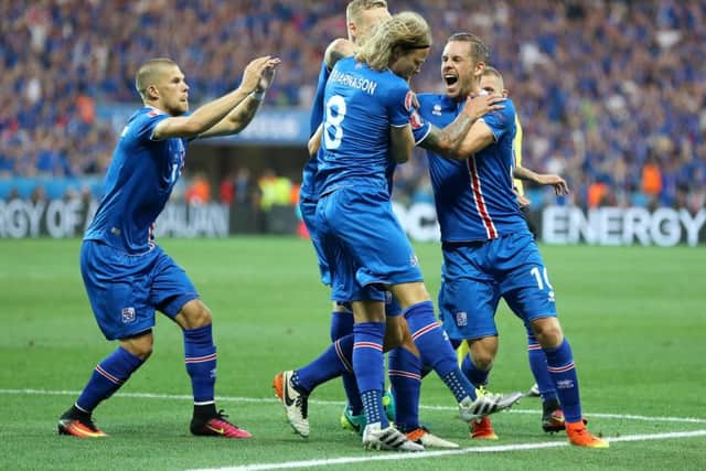 Iceland's Ragnar Sigurdsson (hidden) is mobbed by his team-mates as he celebrates scoring his side's first goal. Picture: Owen Humphreys/PA