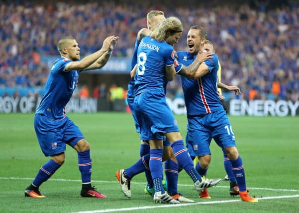 Iceland's Ragnar Sigurdsson (hidden) is mobbed by his team-mates as he celebrates scoring his side's first goal. Picture:  Owen Humphreys/PA