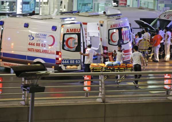 Turkish rescue services gather outside Istanbul's Ataturk airport after two explosions killed several people and wounded scores of others, Turkey's justice minister and another official said. A Turkish official says two attackers have blown themselves up at the airport after police fired at them. (AP Photo/Emrah Gurel)