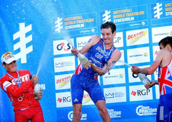 Great Britain's Alistair Brownlee, centre, and Jonathan Brownlee celebrate podium finishes along with Spain's Javier Gomez in Stockholm in 2013.