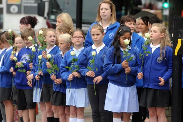 Pupils from Norristhorpe Junior and Infant School  wait with white roses in Heckmondwike. Picture Tony Johnson