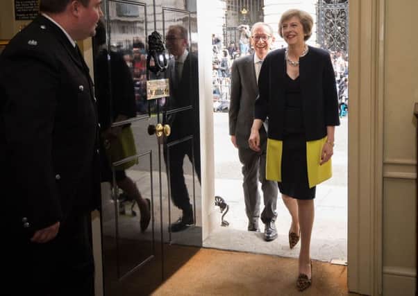 New Prime Minister Theresa May, wearing Amanda Wakeley and her trademark leopard print heels, followed by her husband, Philip (who is already impressing with his dapper outfits), as they walk into 10 Downing Street. Stefan Rousseau/PA Wire